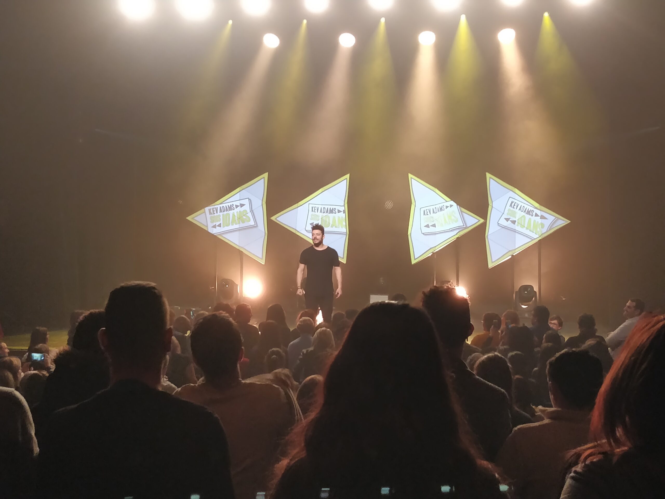 Kev Adams sur scène pendant le spectacle Sois 10 ans
