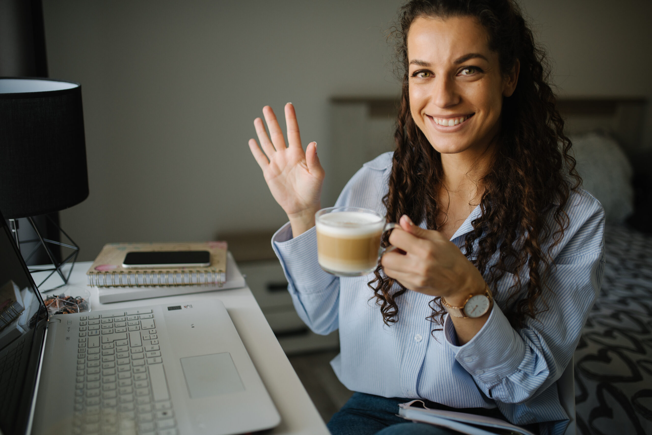 Créatrice souriante devant un ordinateur pour préparer une newsletter digitale