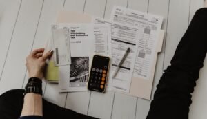 Personne analysant des factures et un calculateur, illustration de l’anxiété financière et de la peur de manquer d’argent